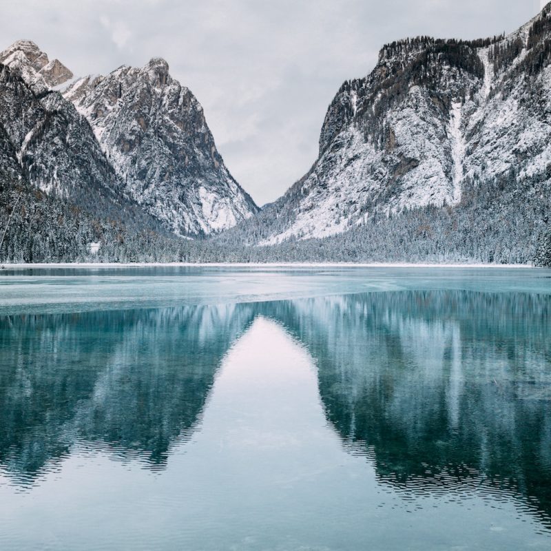 body of water and snow-covered mountains during daytime